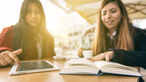 Two friends reading books, normal and Digital way