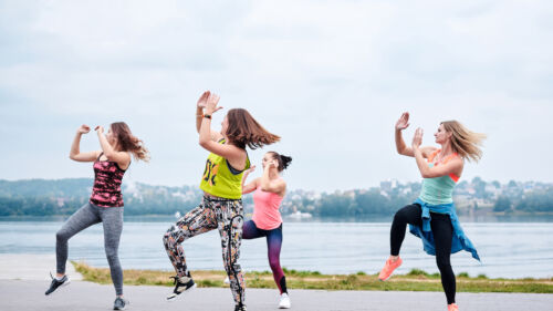 A group of young women, wearing colorful sports outfits, doing z