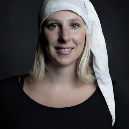 Bilden visar Frida mot en mörk bakgrund med en nattmössa